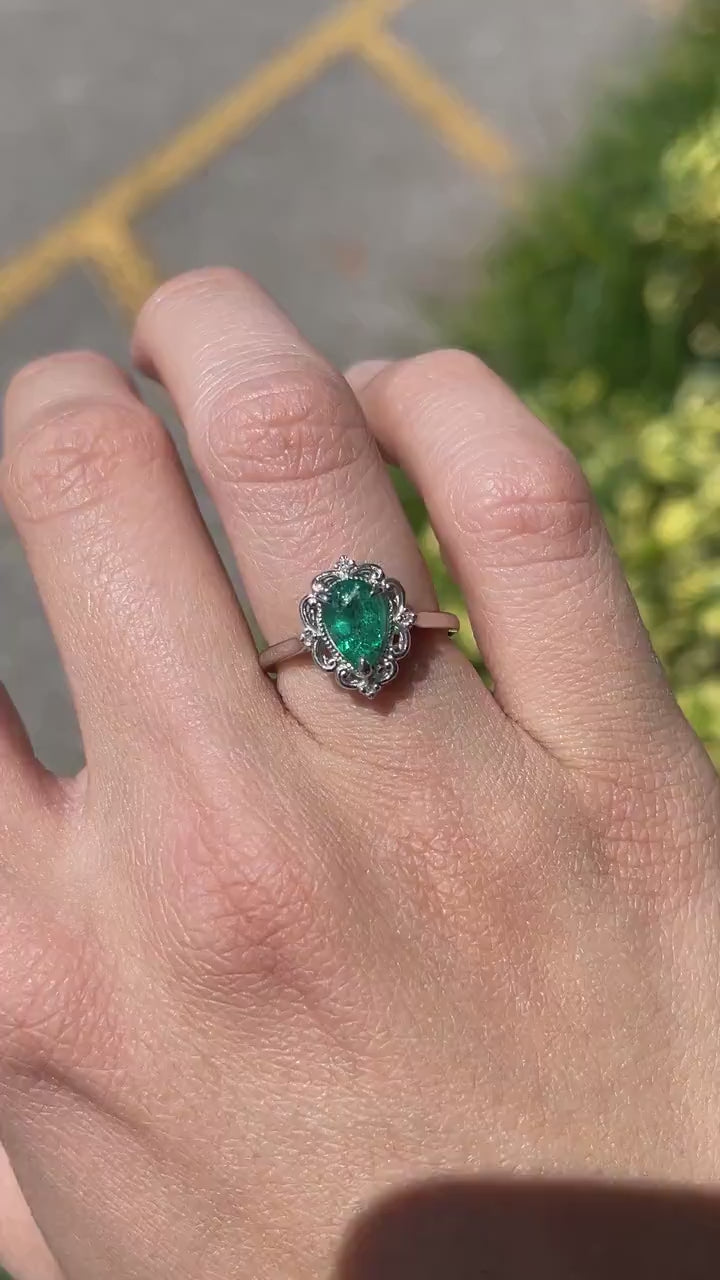 Elegant Floral Design Platinum Ring featuring 1.25tcw Pear Shaped Emerald and Diamonds