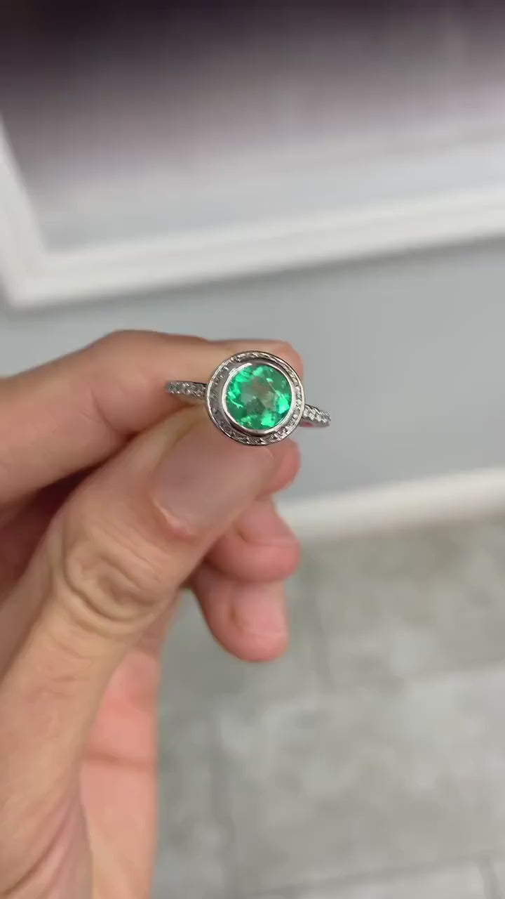 Sparkling round Colombian emerald halo ring in motion revealing vivid green brilliance and diamond fire