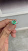 Sparkling round Colombian emerald halo ring in motion revealing vivid green brilliance and diamond fire