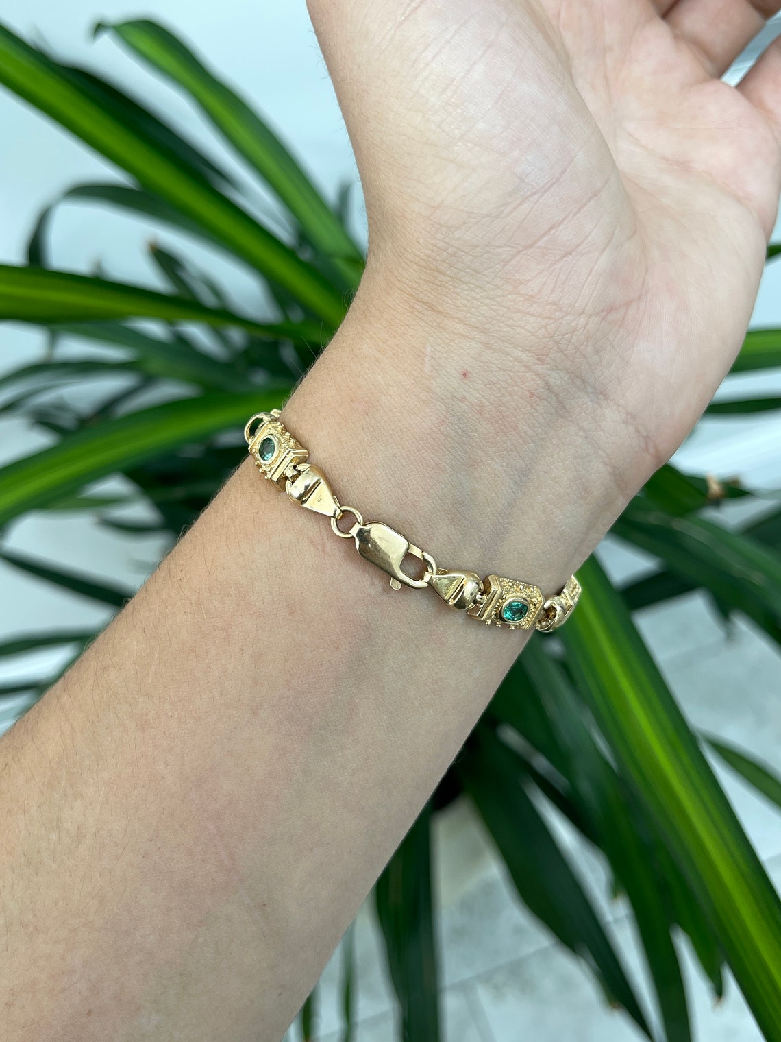 14K gold bracelet with multi-gemstone emeralds including Asscher and oval cuts, featuring Colombian emeralds and remaining 4.90 tcw.