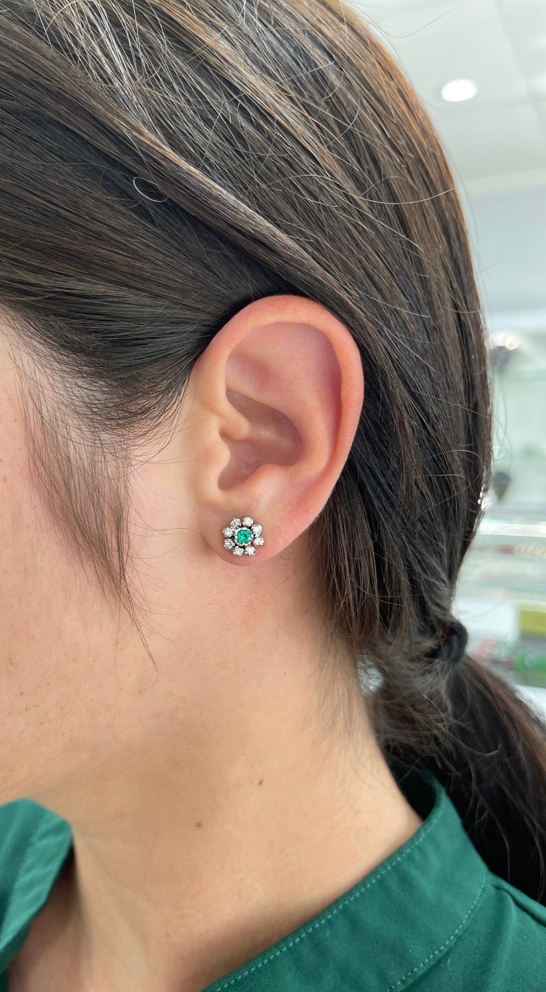 Colombian Emerald floral stud earrings with round cut diamonds, 14K gold, featuring 0.44 carats of emerald accents.