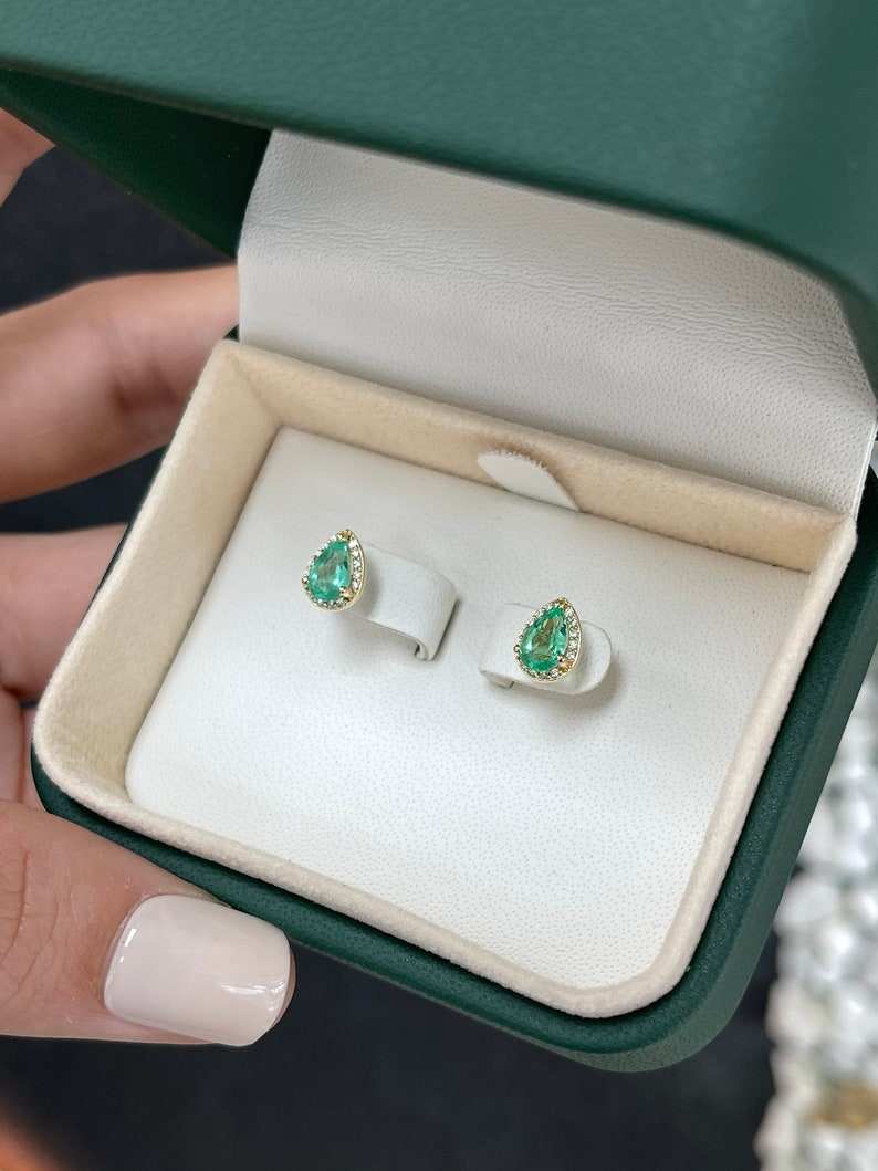 Natural emerald and diamond halo pear cut earrings in 14K gold, featuring 1.07tcw of gemstones by Colombian Emerald.