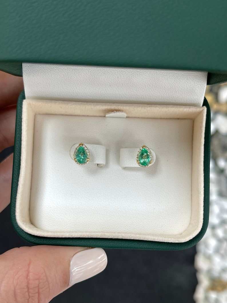 Natural emerald and diamond halo pear-shaped earrings in 14K gold, featuring 1.07 carats total weight from Colombian Emerald.