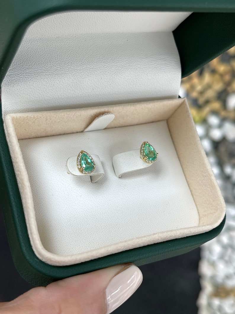 Natural emerald and diamond halo pear-shaped earrings in 14K gold featuring 1.07tcw from Colombian Emerald.