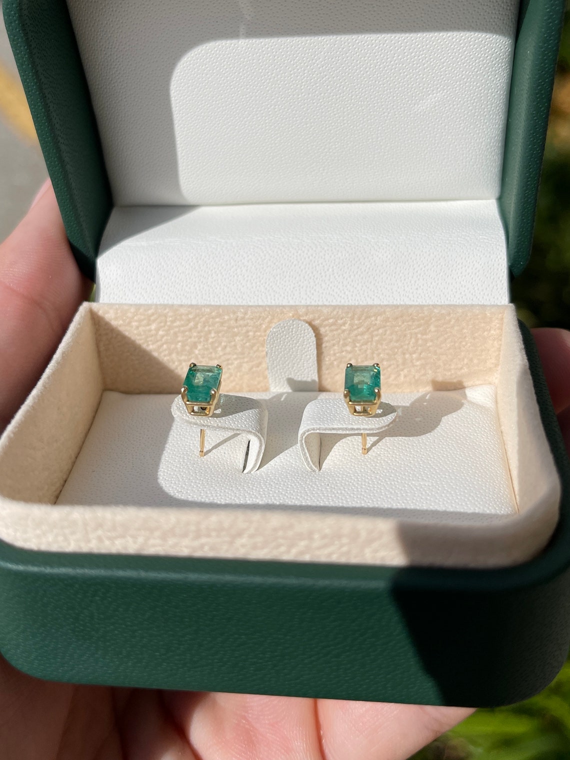 14K Colombian Emerald May birthstone stud earrings featuring 1.81tcw natural emerald cut gemstones.