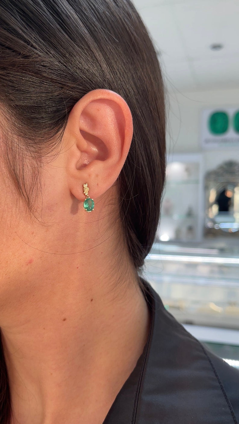 Colombian Emerald 14K gold oval cut green and rose floral dangle earrings with natural emerald gemstones.