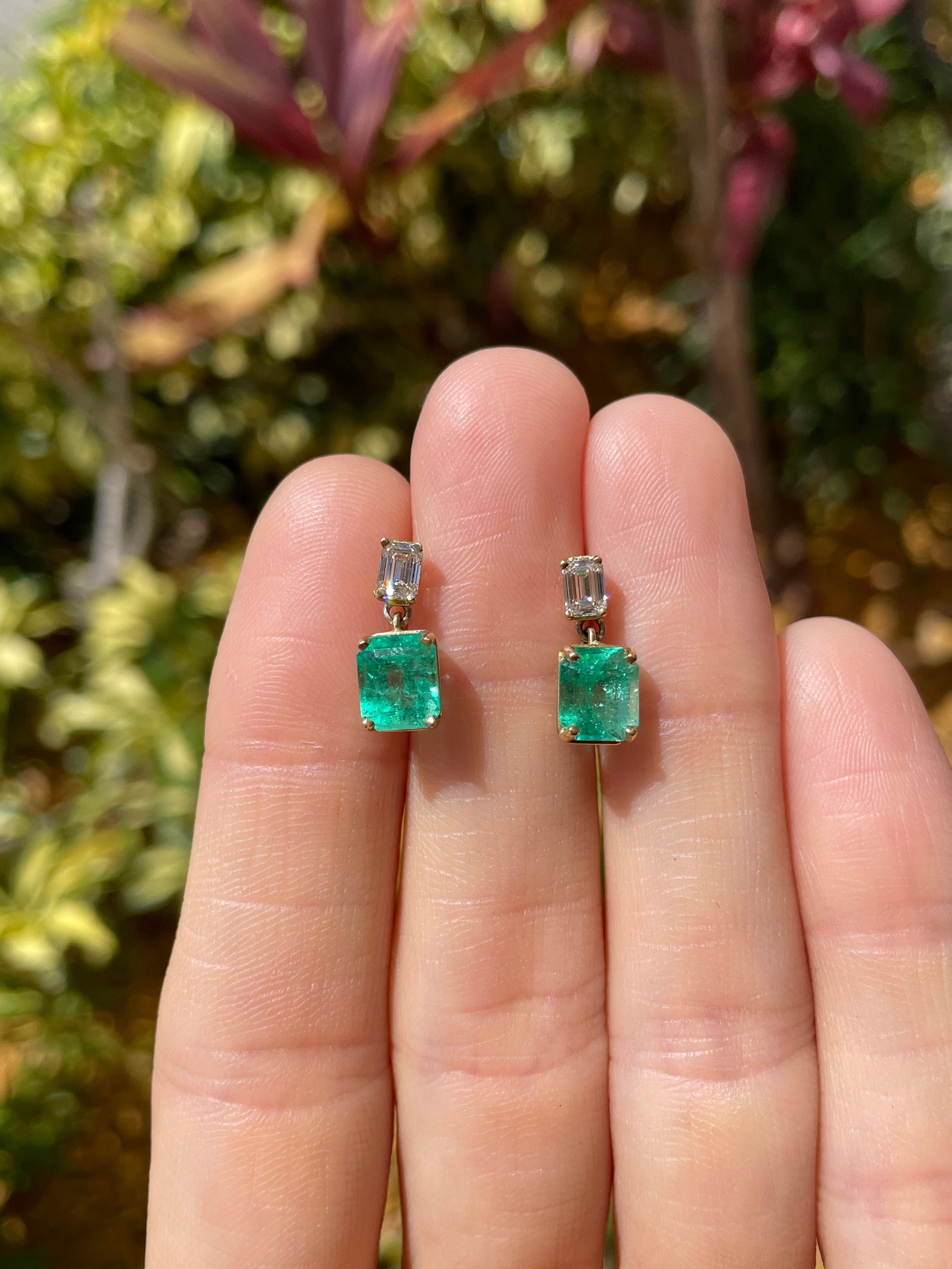 Elongated emerald and diamond dangle earrings in 18K gold with natural transparency, featuring Colombian emeralds and sparkling diamonds.