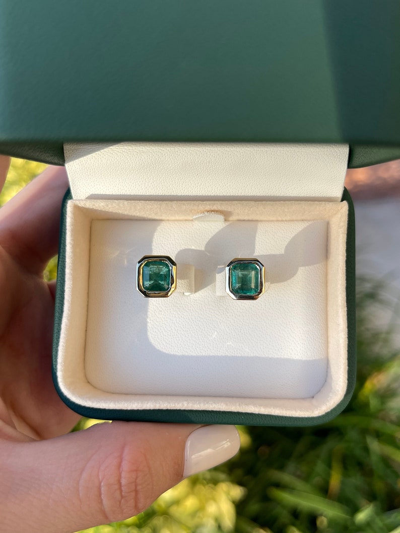 Colombian Emerald earrings with 4.20tcw dark vivid green top emeralds in 14K yellow gold bezel stud settings.