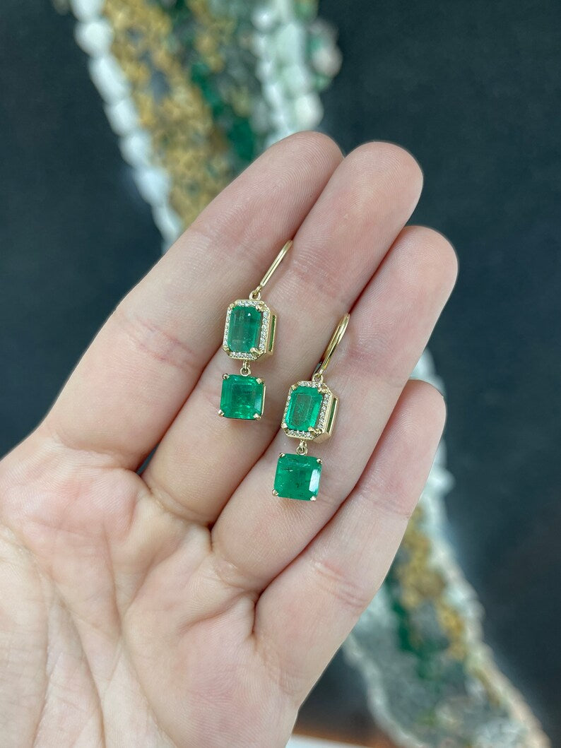 14K gold emerald and diamond halo dangle earrings featuring natural Colombian emeralds and sparkling accents.