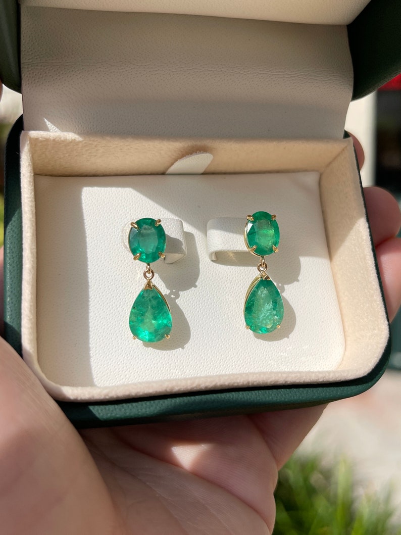 Colombian Emerald earrings featuring 9.78tcw dark green oval and pear-shaped emerald dangles in 18K gold, Earth mined and vibrant.