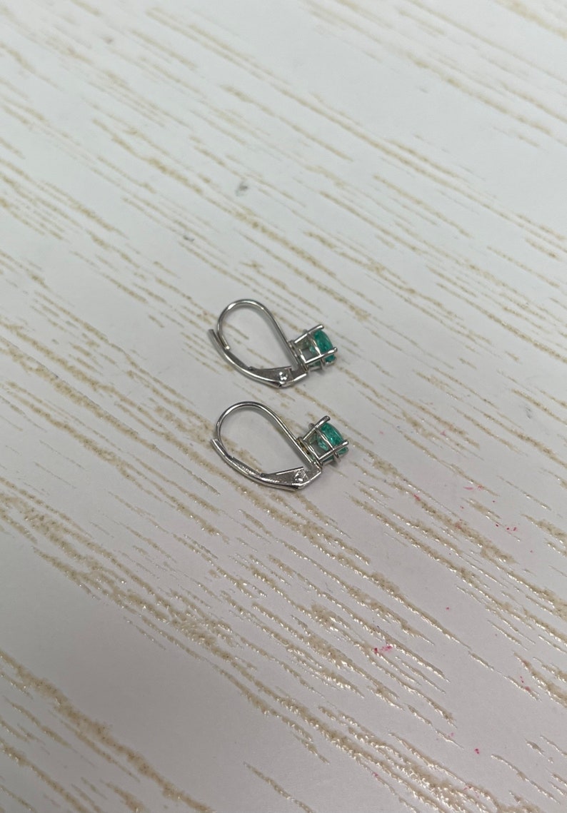 Petite 0.50ctw natural emerald oval cut earrings with 14K gold lever-back clasps, by Colombian Emerald.