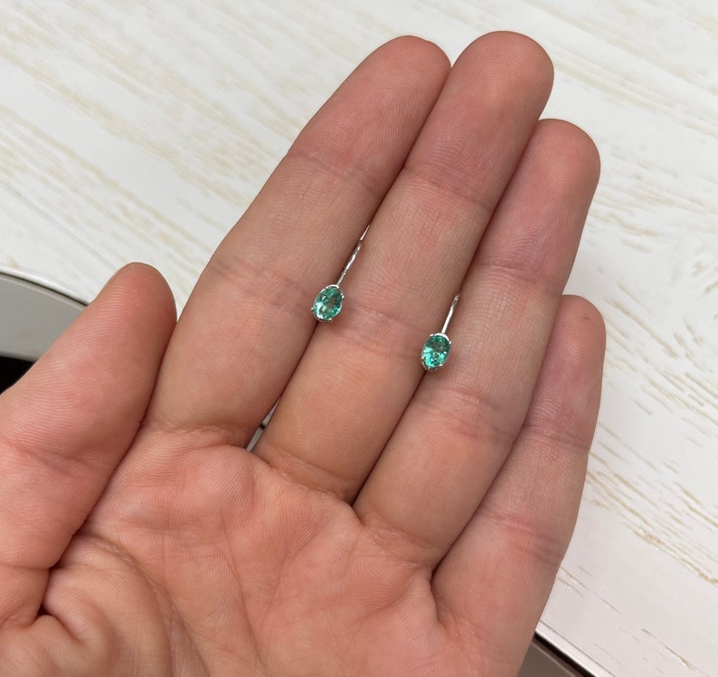 Petite Colombian Emerald earrings with oval cut, 0.50 carats, natural real emeralds, lever-back setting in 14K gold.