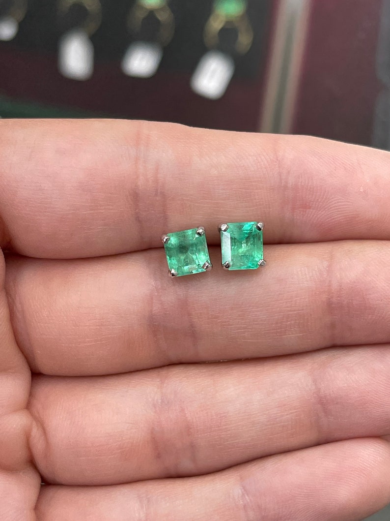 Colombian Emerald Asscher earrings featuring 3.58 carats of rare blue sea green emeralds set in 14K gold.