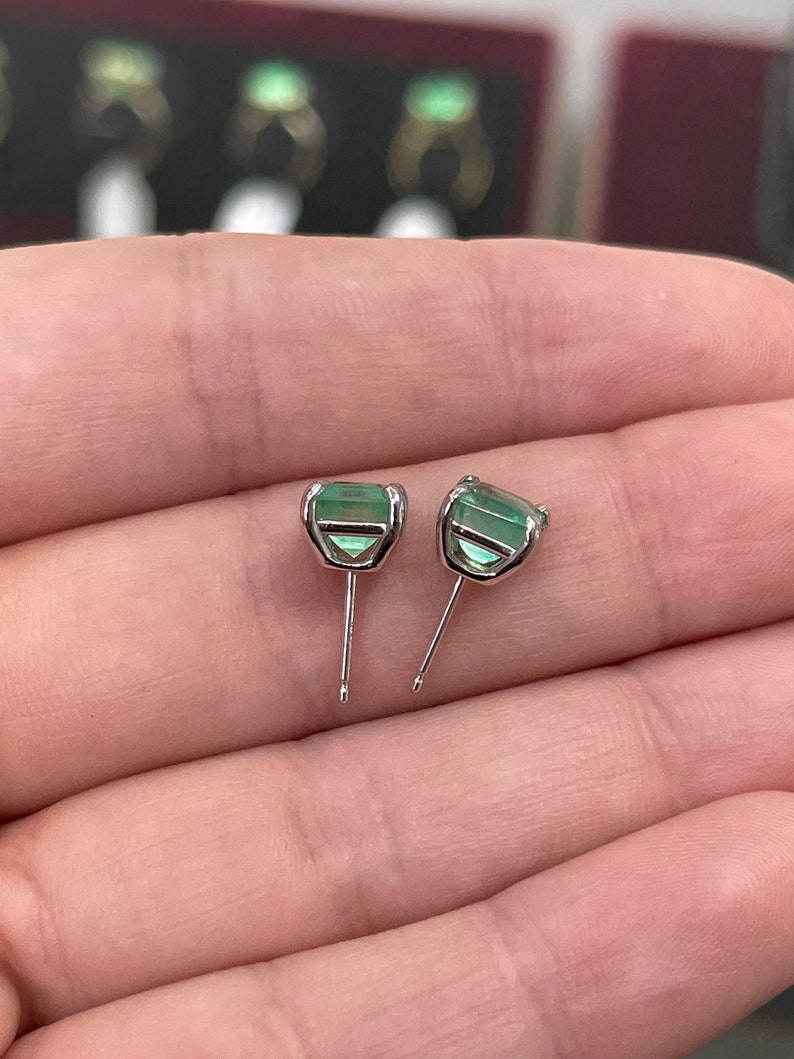 Blue and green Colombian emerald earrings with Asscher cut stones, set in 14K gold, showcasing vibrant gemstone brilliance.