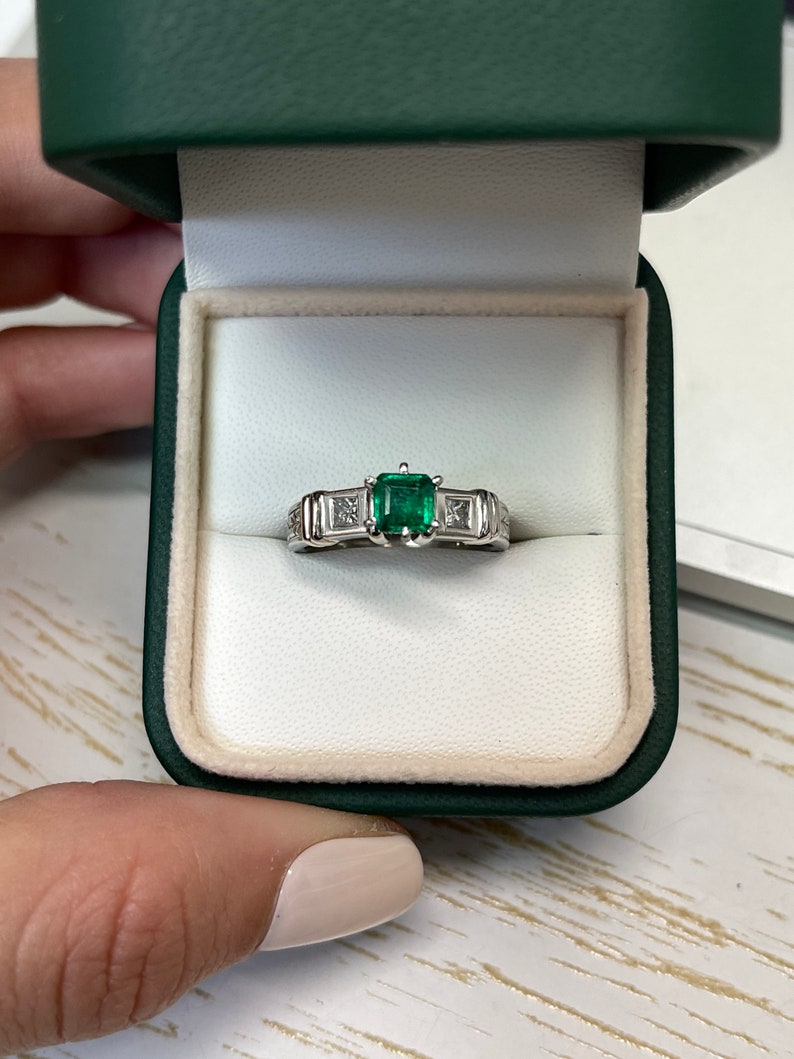 Colombian Emerald 3-stone engagement ring with 1.20tcw Asscher emerald and princess cut diamond accents in 18K gold.