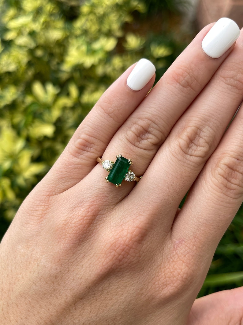 Colombian Emerald 18K three-stone engagement ring with deep dark Alpine green emerald cut and brilliant round diamonds