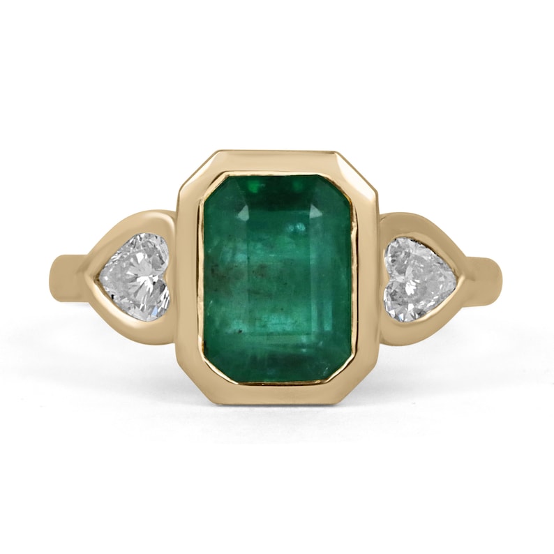 Colombian Emerald 18K yellow gold engagement ring with 2.97tcw emerald and heart-cut diamonds, three-stone design.