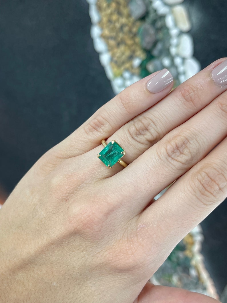 Colombian Emerald 4.10 carat natural emerald cut solitaire engagement ring with four prongs in yellow gold.