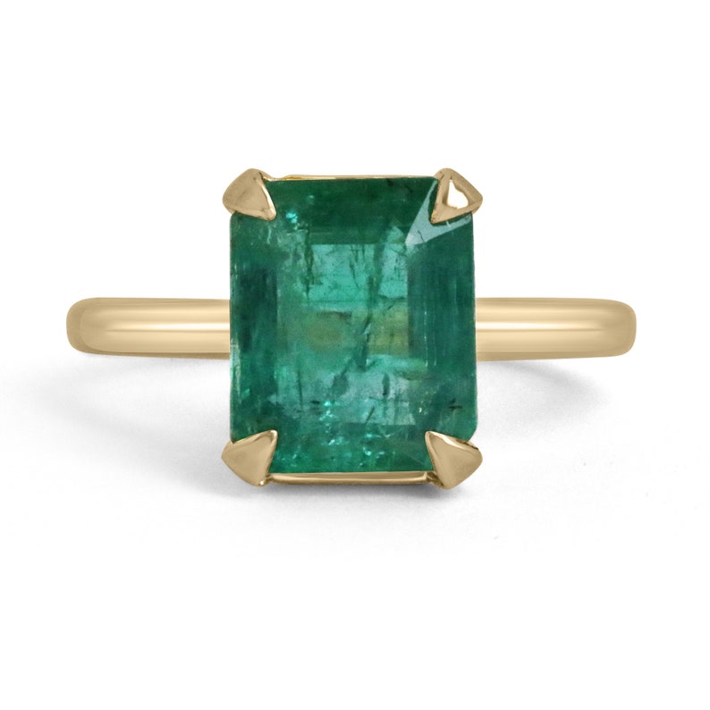 Colombian Emerald 4.10 carat yellow gold solitaire engagement ring with emerald cut, four prongs, and half bezel setting.