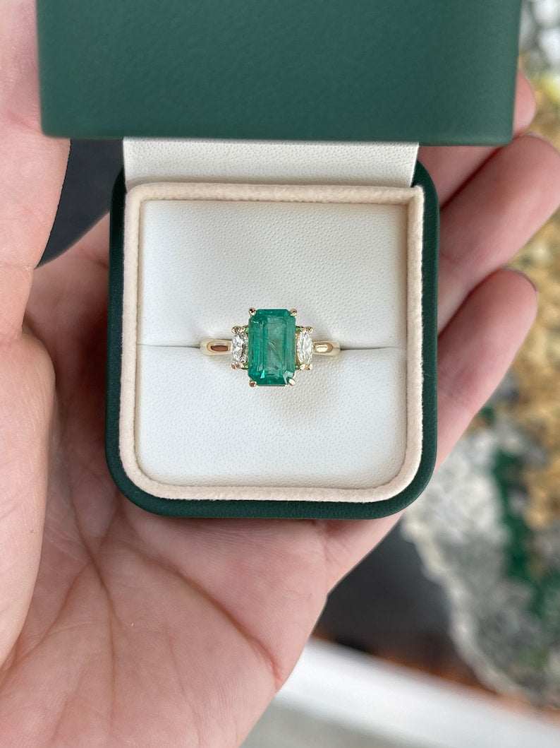 Medium bluish green emerald and diamond three-stone engagement ring with marquise cuts in 14K gold, featuring Colombian emeralds.