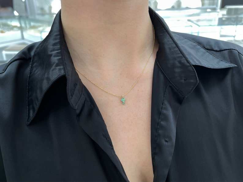 Petite 0.15tcw round Colombian emerald cross pendant on 14K yellow gold, designed for children’s baptism or religious occasions.