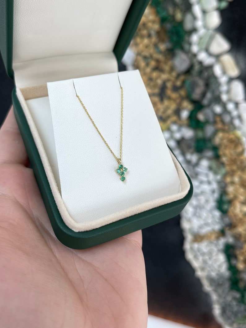 Petits round Colombian emerald child’s baptism cross necklace in 14K yellow gold, 0.15tcw with a religious design.