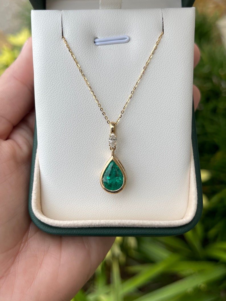 Colombian Emerald pendant necklace with 4.35tcw pear cut emerald, marquise diamonds, 14K gold teardrop bezel setting, bail accent.
