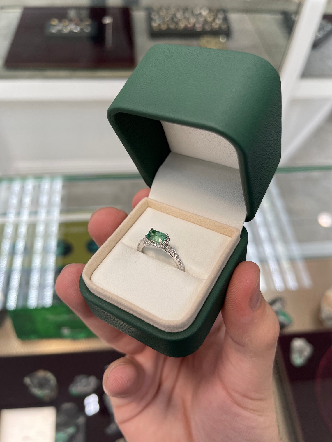 14K Colombian Emerald engagement ring with 1.25ctw east-to-west emerald cut center stone and diamond halo setting