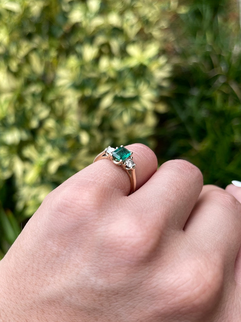 Dark bluish-green emerald and round diamonds 3-stone engagement ring in 14K Colombian Emerald brand with detailed gemstone settings