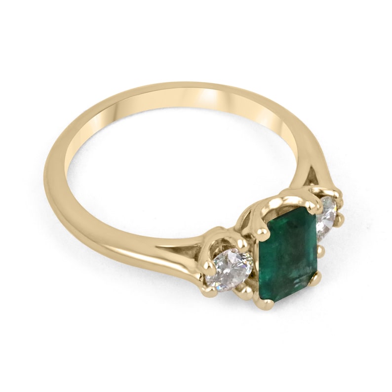 Dark bluish-green emerald and round diamond three-stone engagement ring in 14K gold, featuring Colombian Emerald brand.