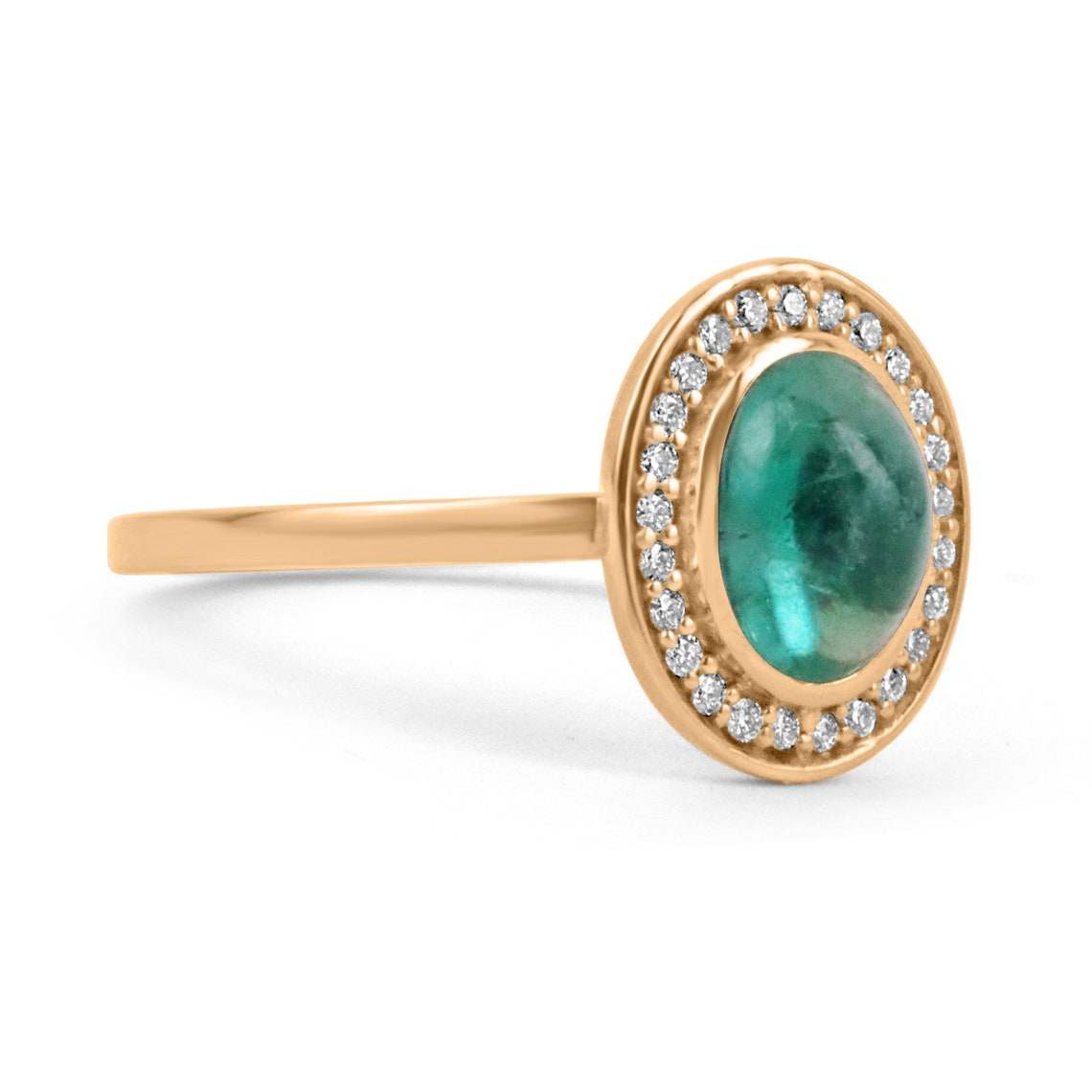 Colombian emerald oval cabochon ring with diamond pave halo, featuring a contemporary design for ladies, showcasing vibrant green gemstone.