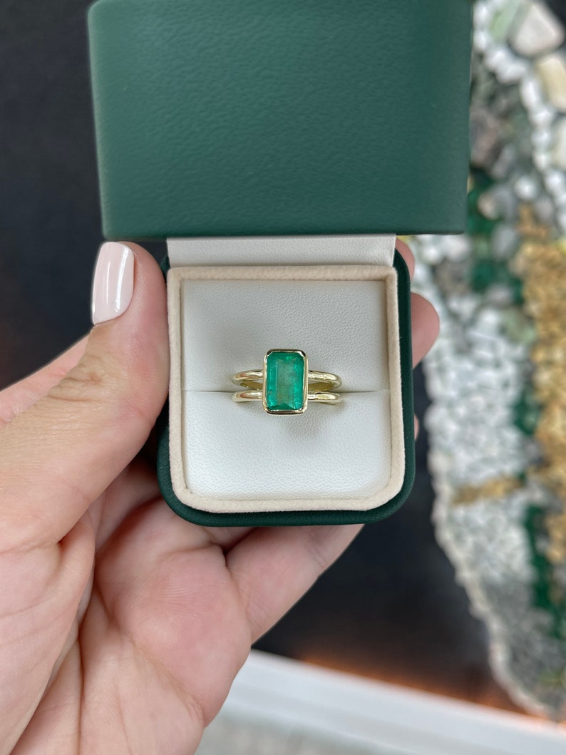 Colombian Emerald ladies ring with 2.05ct vivid green emerald cut solitaire, 14K gold split shank right-hand ring.