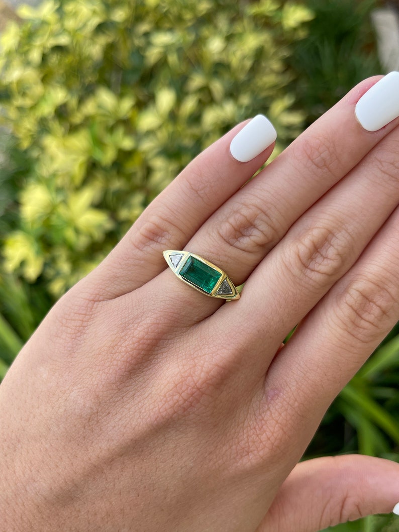 Ladies Colombian Emerald gold gypsy ring featuring 2.35cttw three-stone baguette and trillion cut diamonds in 18K AAA quality.