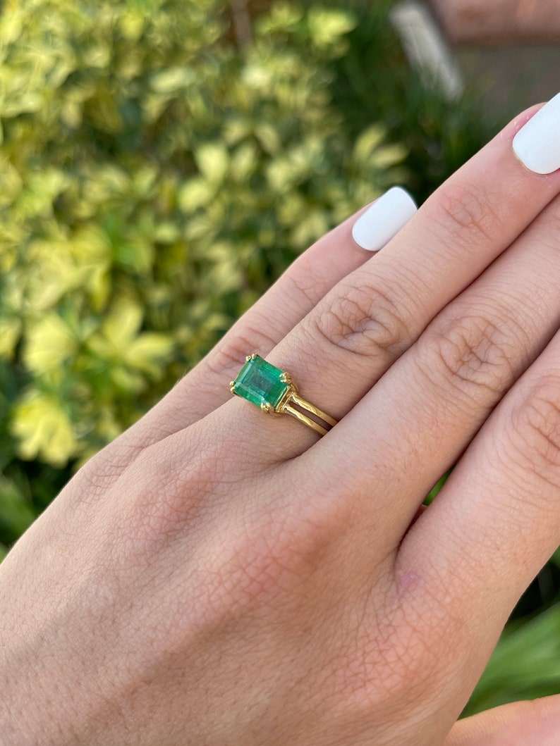 Colombian Emerald ladies ring with 2.68ct emerald cut yellow-green gemstone, 18K gold split shank and double claw prong setting.