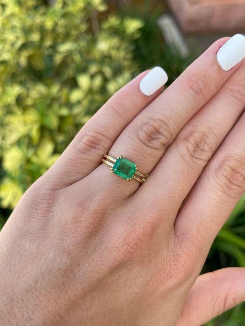Colombian Emerald ladies ring with 2.68ct emerald cut yellowish-green stone, double claw prong, gold split shank, east-west setting