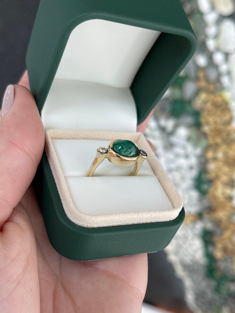 Ladies emerald ring featuring a 4.50tcw oval dark green emerald cabochon with diamond accents in 14K gold, Colombian Emerald brand.