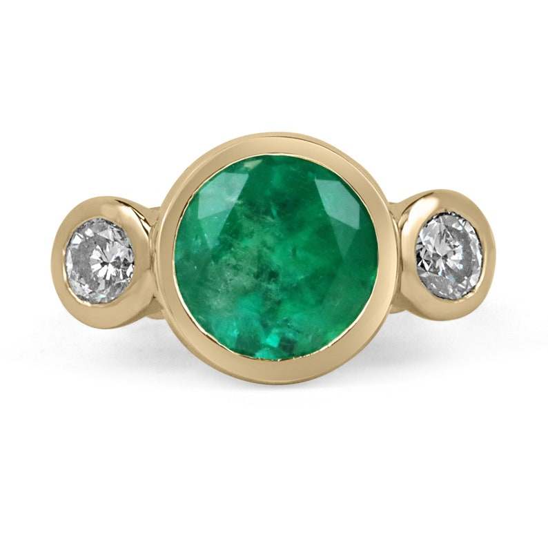 Ladies gold ring with three-stone design featuring 6.50 tcw Colombian Emerald and VS diamonds in 18K gold.