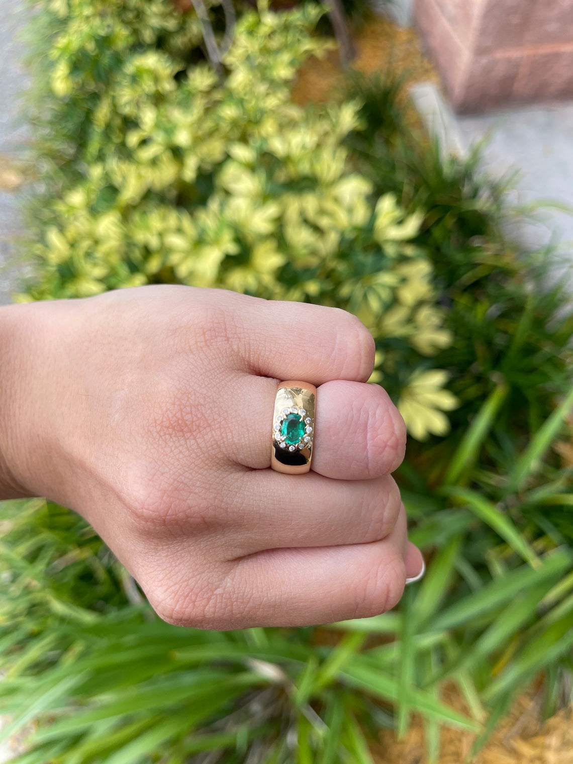 Colombian Emerald oval cut ring with diamond halo accents, 14K gold band, showcasing vibrant green gemstones and elegant design.