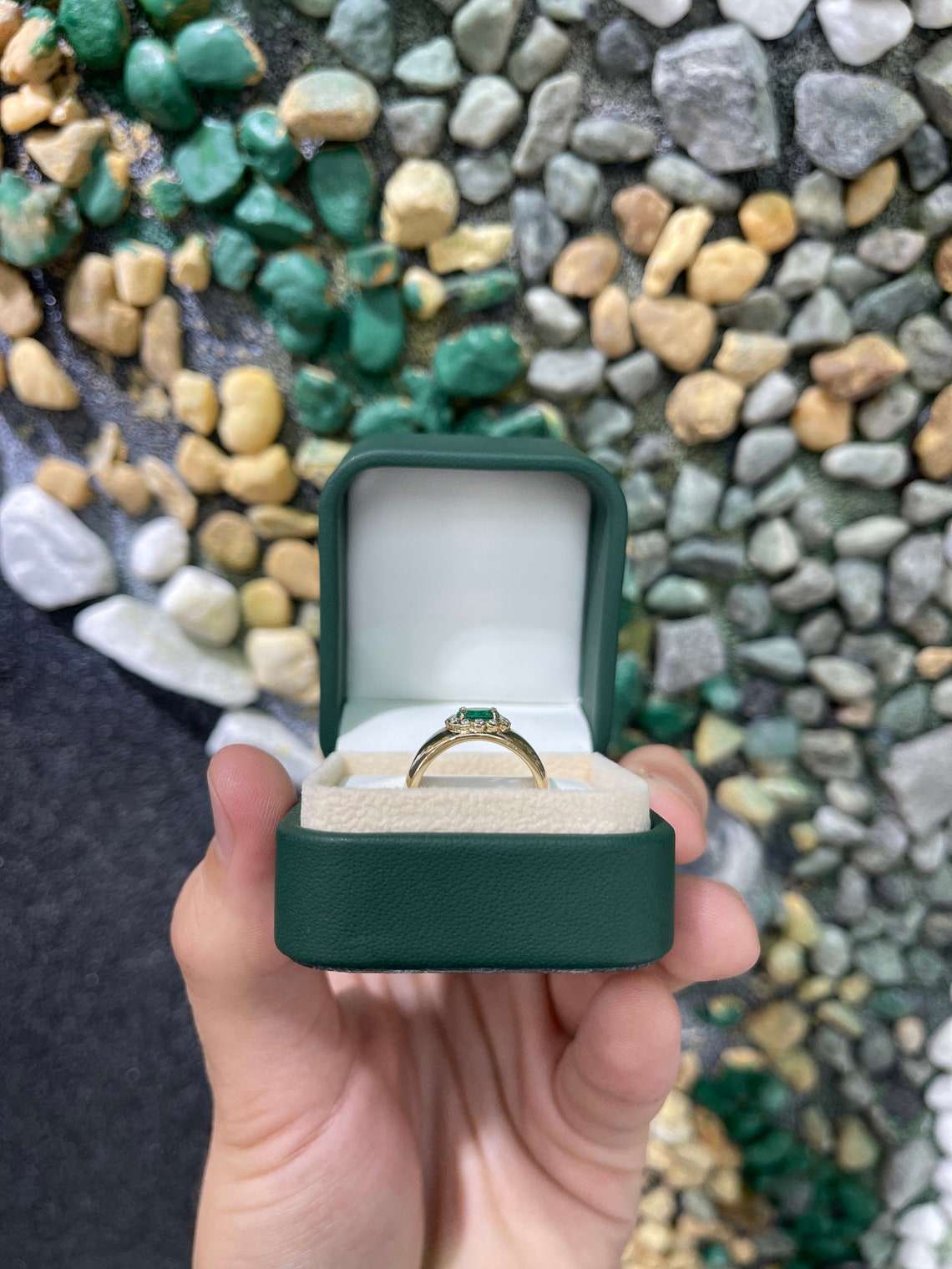 Oval cut Colombian emerald ring with diamond halo accents in 14K gold, showcasing the vibrant green gemstone and sparkling details.