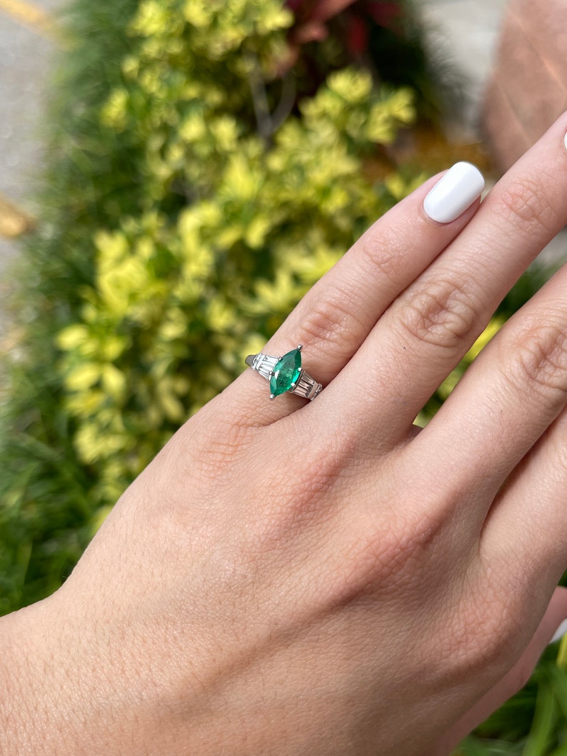 14K Colombian Emerald and diamond ring featuring marquise cut emeralds and tapered baguette diamonds on a sleek band.