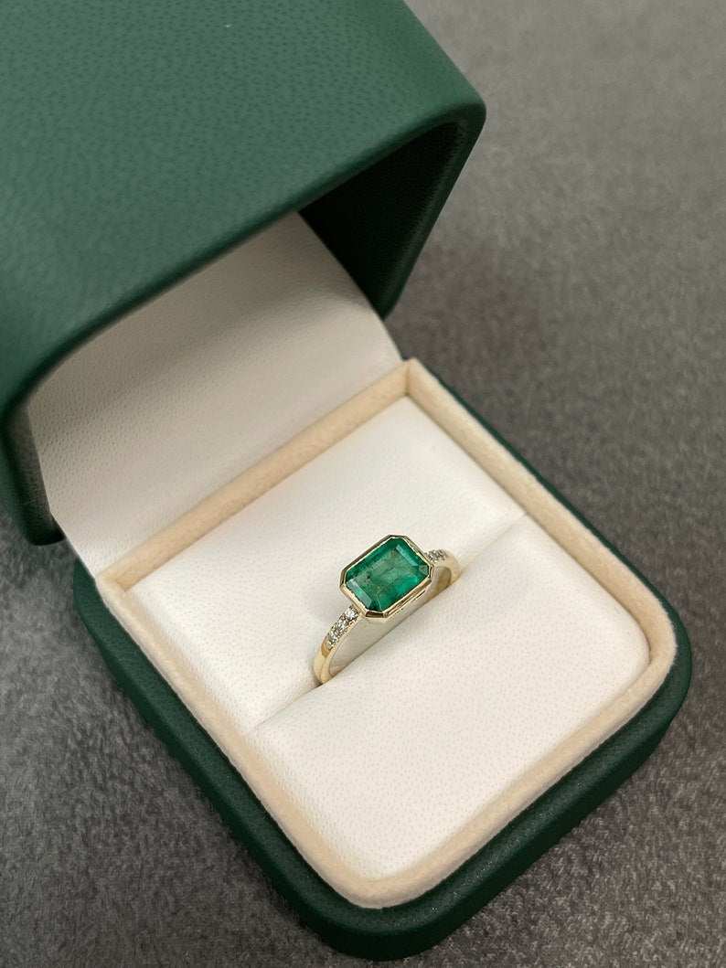Colombian Emerald natural emerald cut ring with diamond accents in 14K bezel setting, featuring a sleek and elegant design.