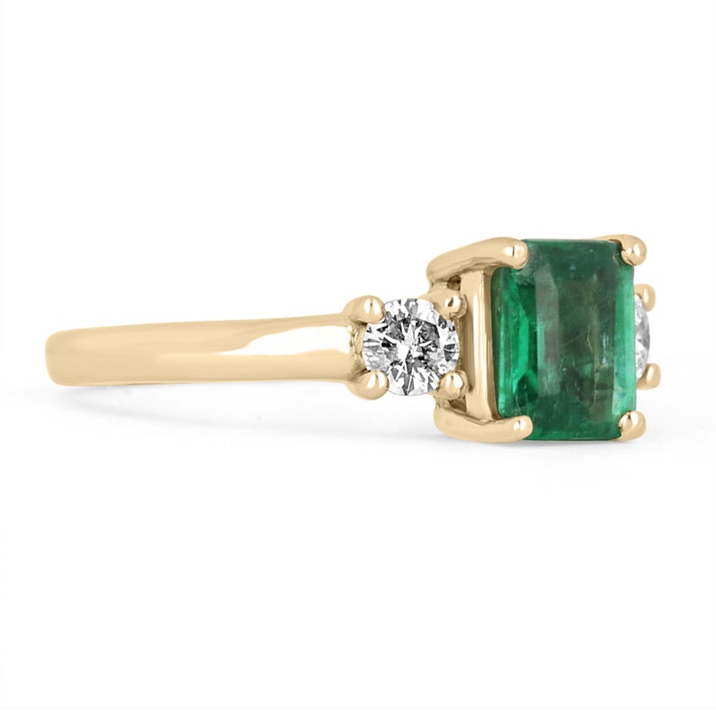 Colombian Emerald 14K gold three-stone ring with brilliant round diamonds, showcasing a transparent emerald center and elegant design.