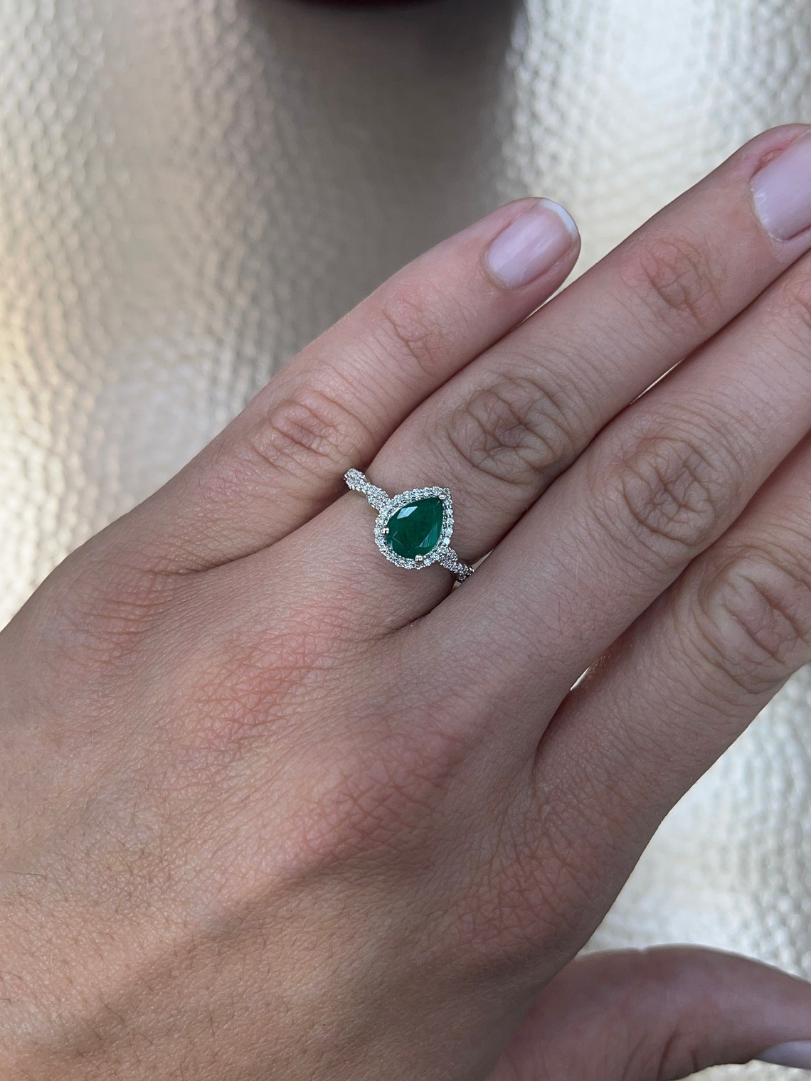 Colombian Emerald natural pear-cut engagement ring with diamond halo accents in 14K gold.