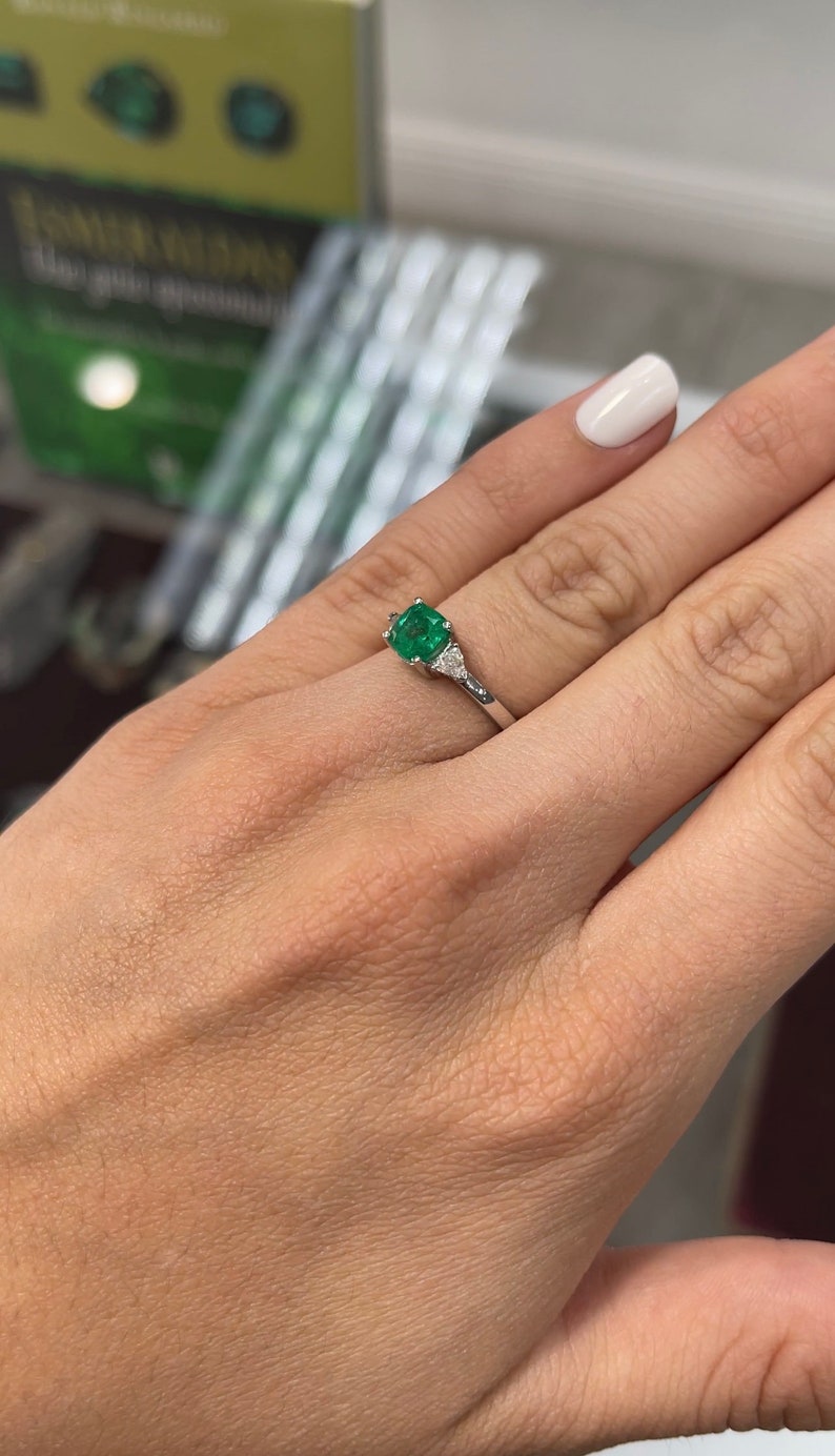 18K Colombian Emerald cushion cut three stone diamond ring with 1.48tcw, featuring vibrant green emeralds and sparkling diamonds.