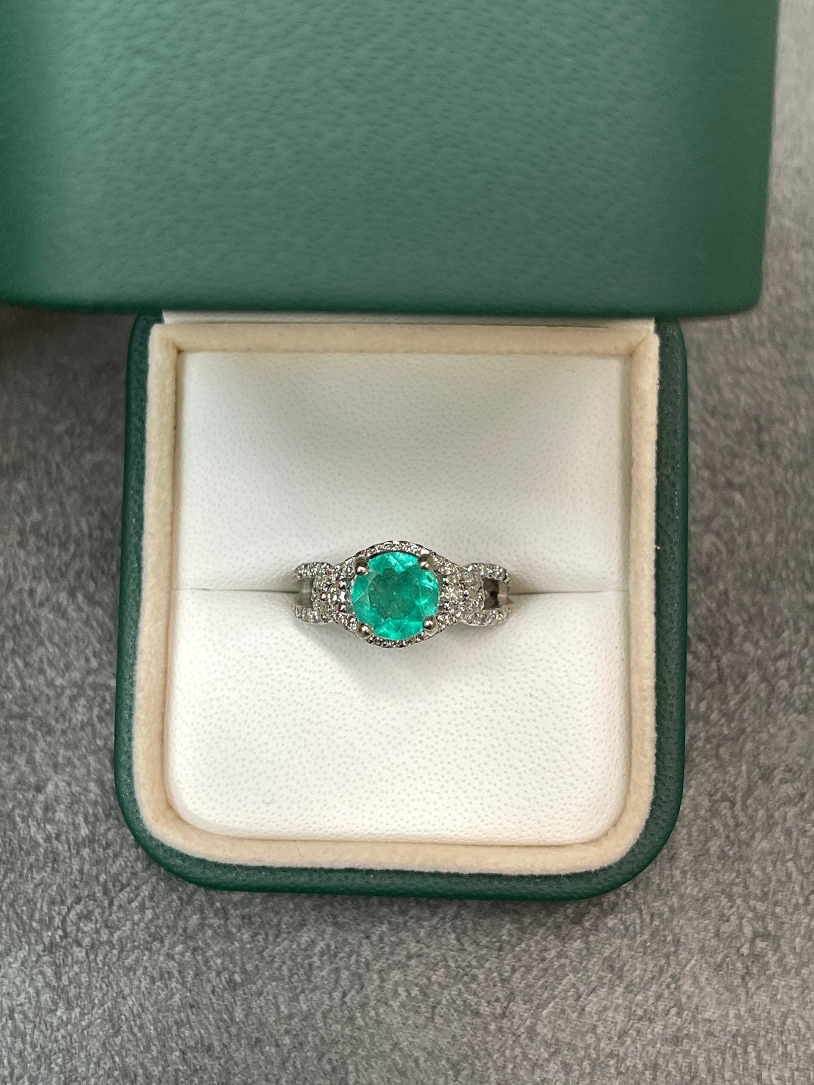 Round Colombian emerald engagement ring with diamond halo in 14K gold, featuring 1.57 tcw of gemstones and intricate detailing.
