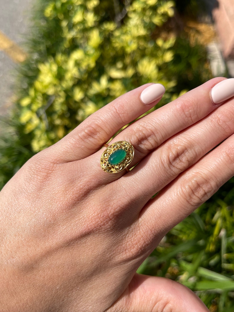Natural Colombian emerald ring with 2.03cts elongated oval cabochon, handmade floral design in 18K gold.