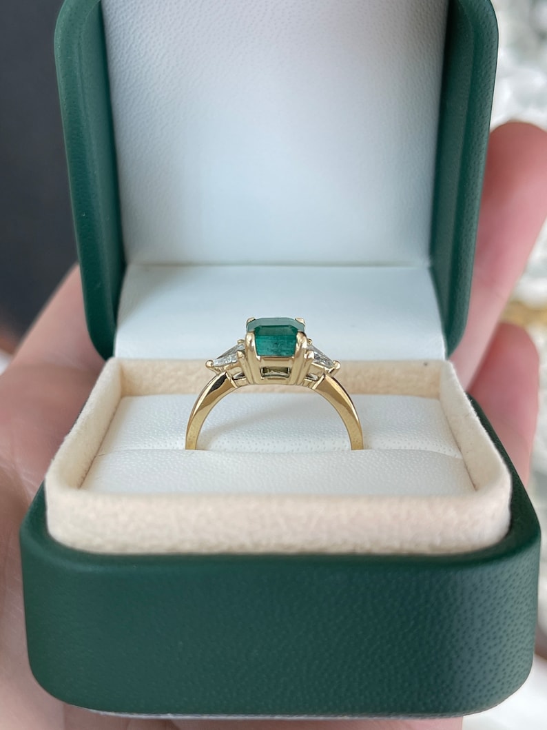 14K gold 3-stone engagement ring with lush green Asscher emerald and trillion cut diamond accents, by Colombian Emerald.