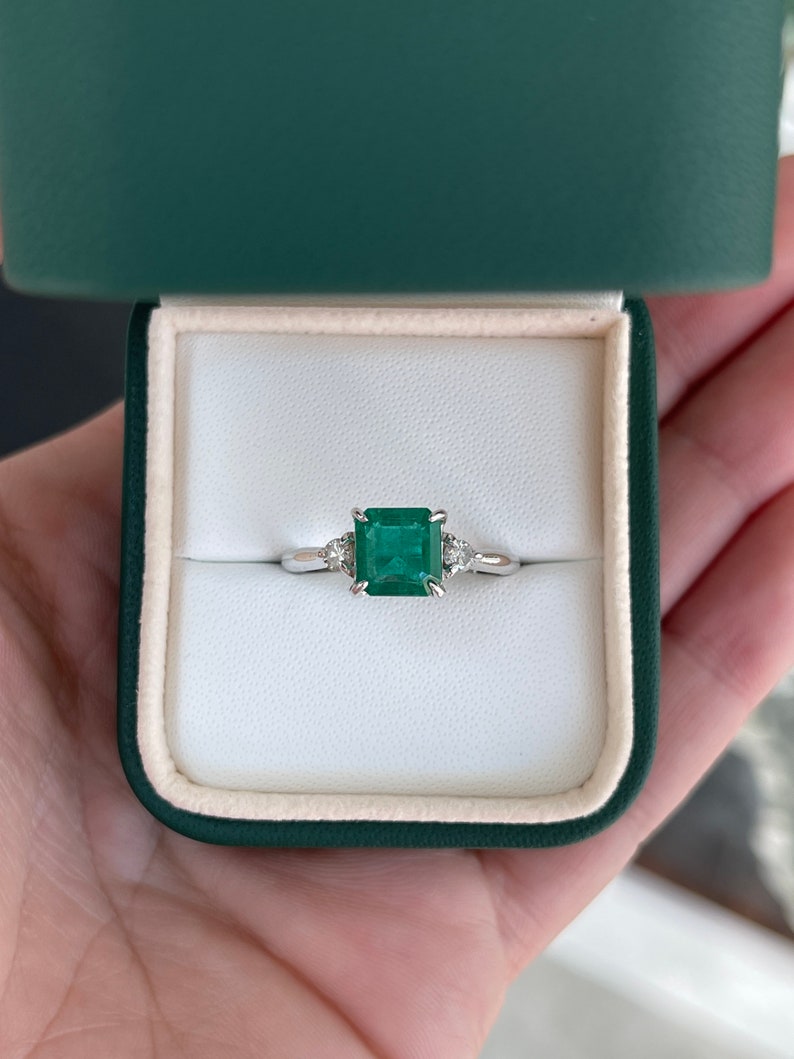 Dark green genuine emerald and diamond 3-stone engagement ring in 14K gold with Asscher cut emeralds and sparkling diamonds.