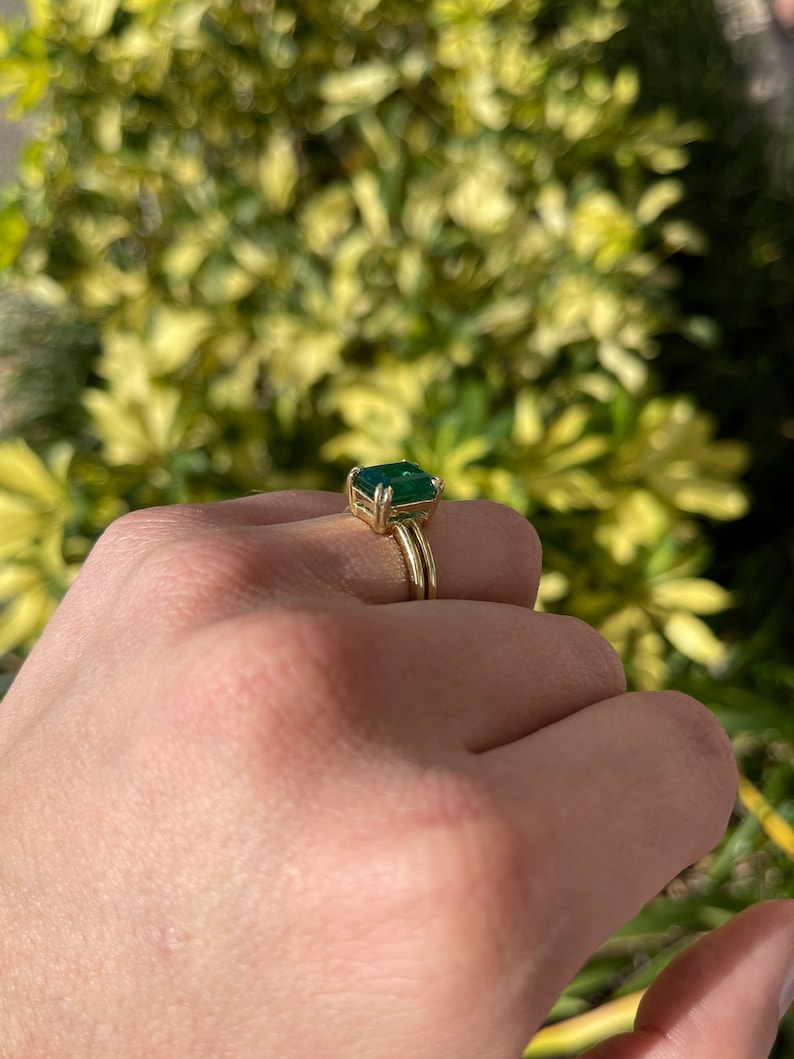 Colombian Emerald 3.28ct deep green emerald cut solitaire gold ring with 4 double prong setting in 18K gold.
