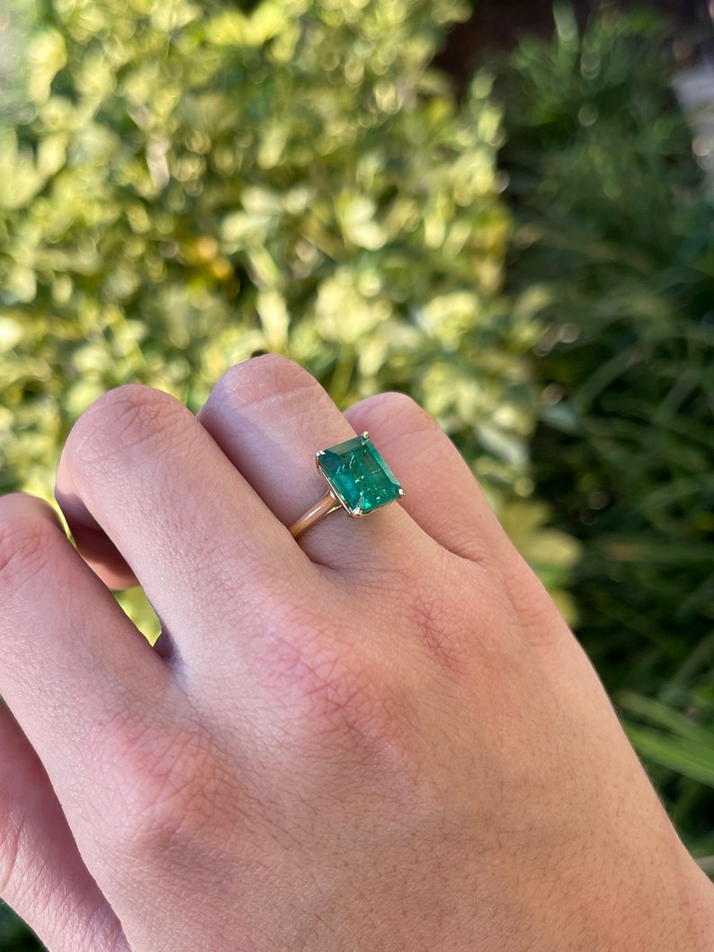Colombian Emerald 3.84 Carat 18K gold solitaire engagement ring with emerald cut center stone on a plain band